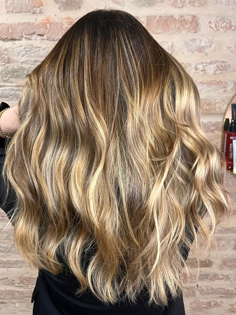 Capelli lunghi e mossi con radici scure e lunghezze bionde, visti da dietro