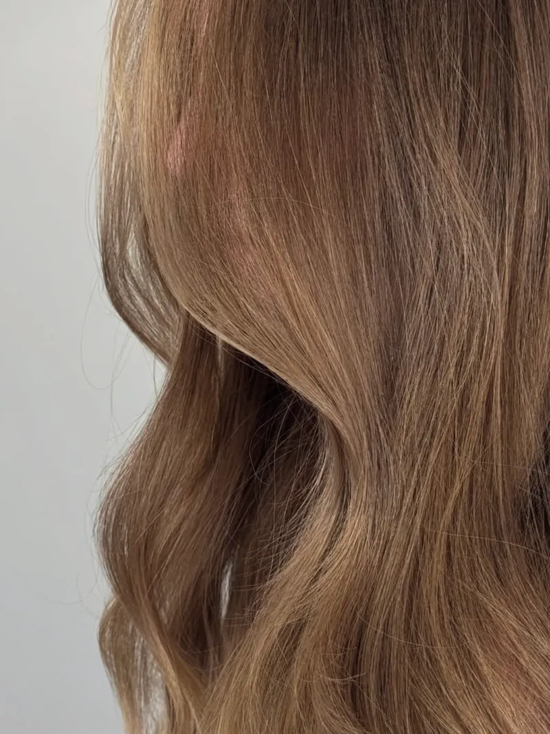 Primo piano delle onde su capelli castano chiaro