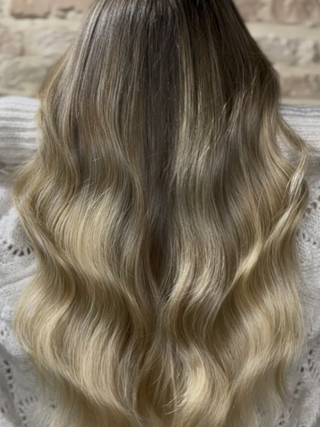 Capelli lunghi con sfumatura dal castano al biondo, mossi, visti da dietro